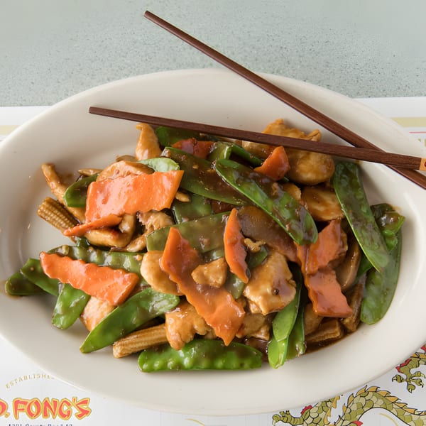 D. Fong's Chinese Cuisine's chicken stir-fry with snow peas, carrots, and baby corn, served with chopsticks.