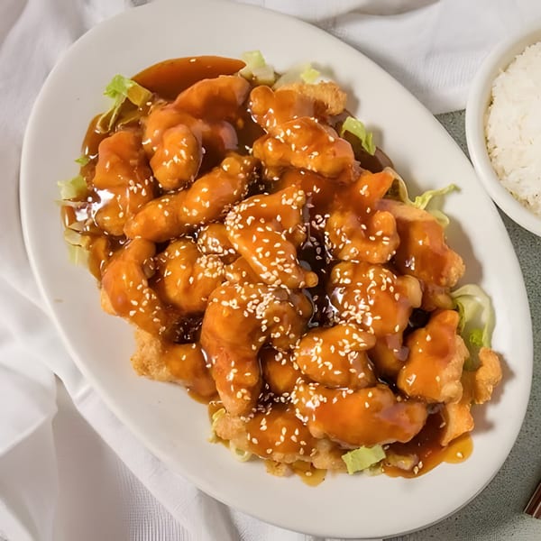 D. Fong's Chinese Cuisine's sesame chicken, a plate of crispy chicken pieces coated in a sweet, savory sauce.