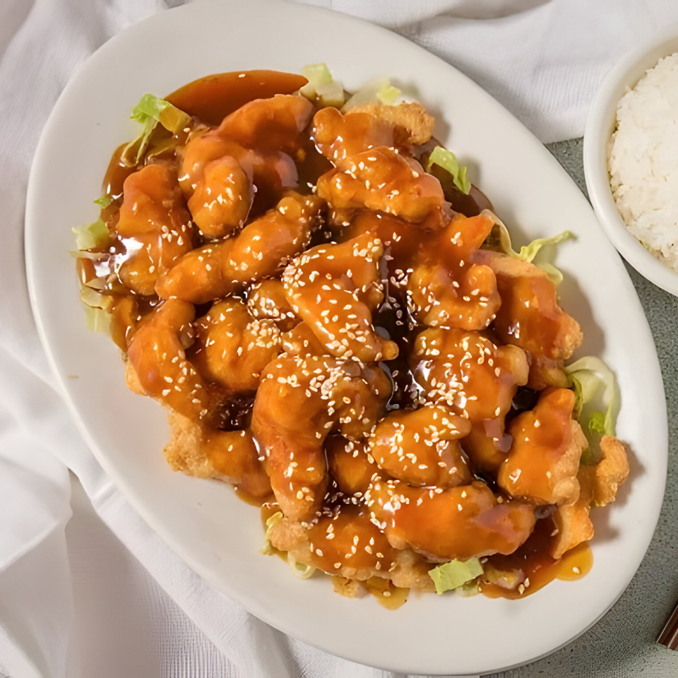 D. Fong's Chinese Cuisine's sesame chicken, a plate of crispy chicken pieces coated in a sweet, savory sauce.